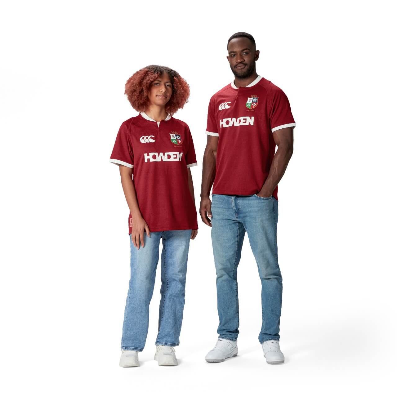 A female and male standing on a white background, wearing the Lions men's jersey and jeans